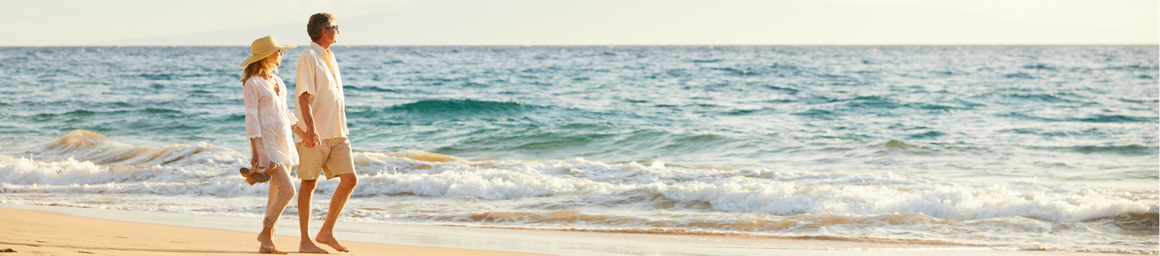 Older couple walking hand in hand along a peaceful beach